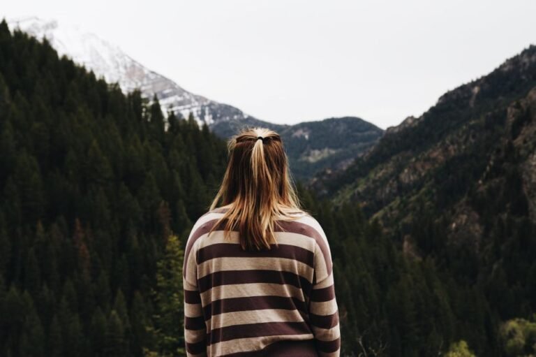 back-view-of-woman-hiking-in-mountain-forest-with-view avoiding ticks